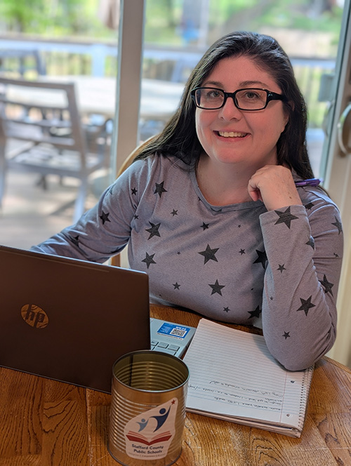Shannon seated at a desk with a laptop and notebook